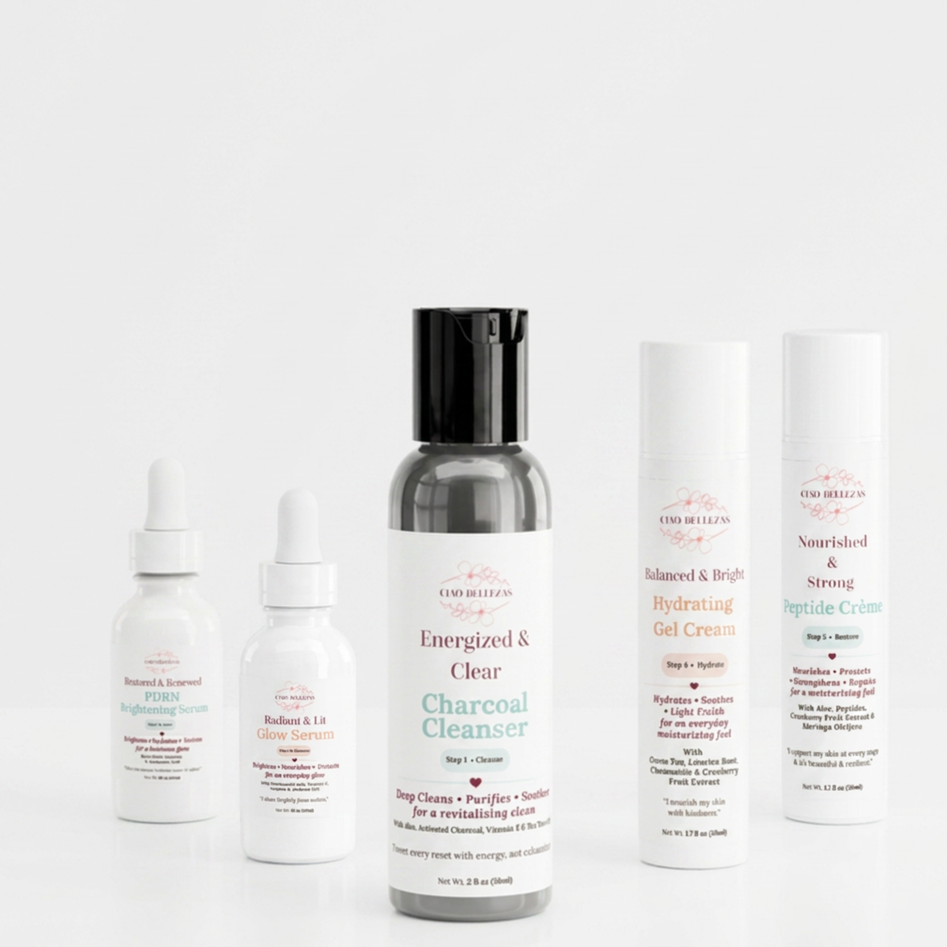 A three-piece build your own  skincare set from Good Healers of Nashville arranged on a seamless white background. The set includes a charcoal cleanser in a dark gray bottle with a black cap, a brightening serum in a white dropper bottle, a glow serum in a white dropper bottle, a hydrating gel cream in a white tube, and a strong peptide cream in a white tube.
