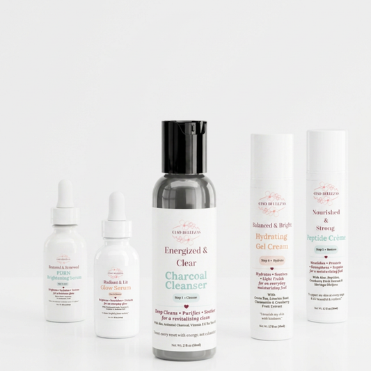 A three-piece build your own  skincare set from Good Healers of Nashville arranged on a seamless white background. The set includes a charcoal cleanser in a dark gray bottle with a black cap, a brightening serum in a white dropper bottle, a glow serum in a white dropper bottle, a hydrating gel cream in a white tube, and a strong peptide cream in a white tube.